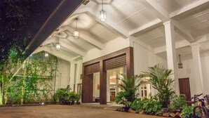 A spacious entrance with a covered walkway, potted plants, and a bicycle parked outside. - The Lakeside Hotel at Nuwarawewa (Anuradhapura)