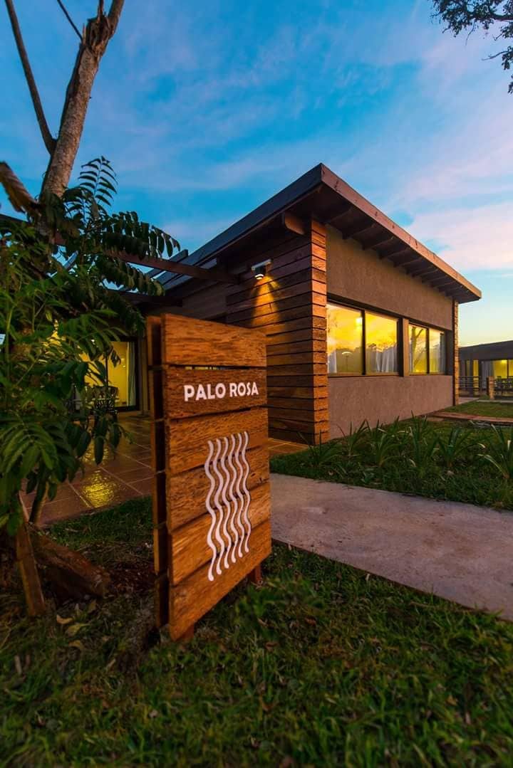 Un edificio moderno con un cartel que dice 'Palo Rosa' y un sendero que lleva a él.