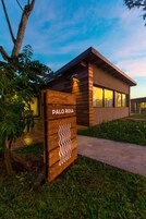 A modern building with a sign reading 'Palo Rosa' and a pathway leading to it.