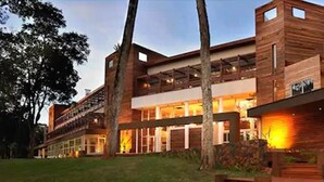 Un edificio moderno de dos plantas con techo plano, ventanas amplias y fachada de madera.