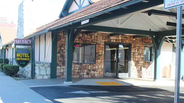 A motel with a stone facade, a neon 'OPEN' sign, and a 'VACANCY' sign. - Best Whittier Inn (Whittier)