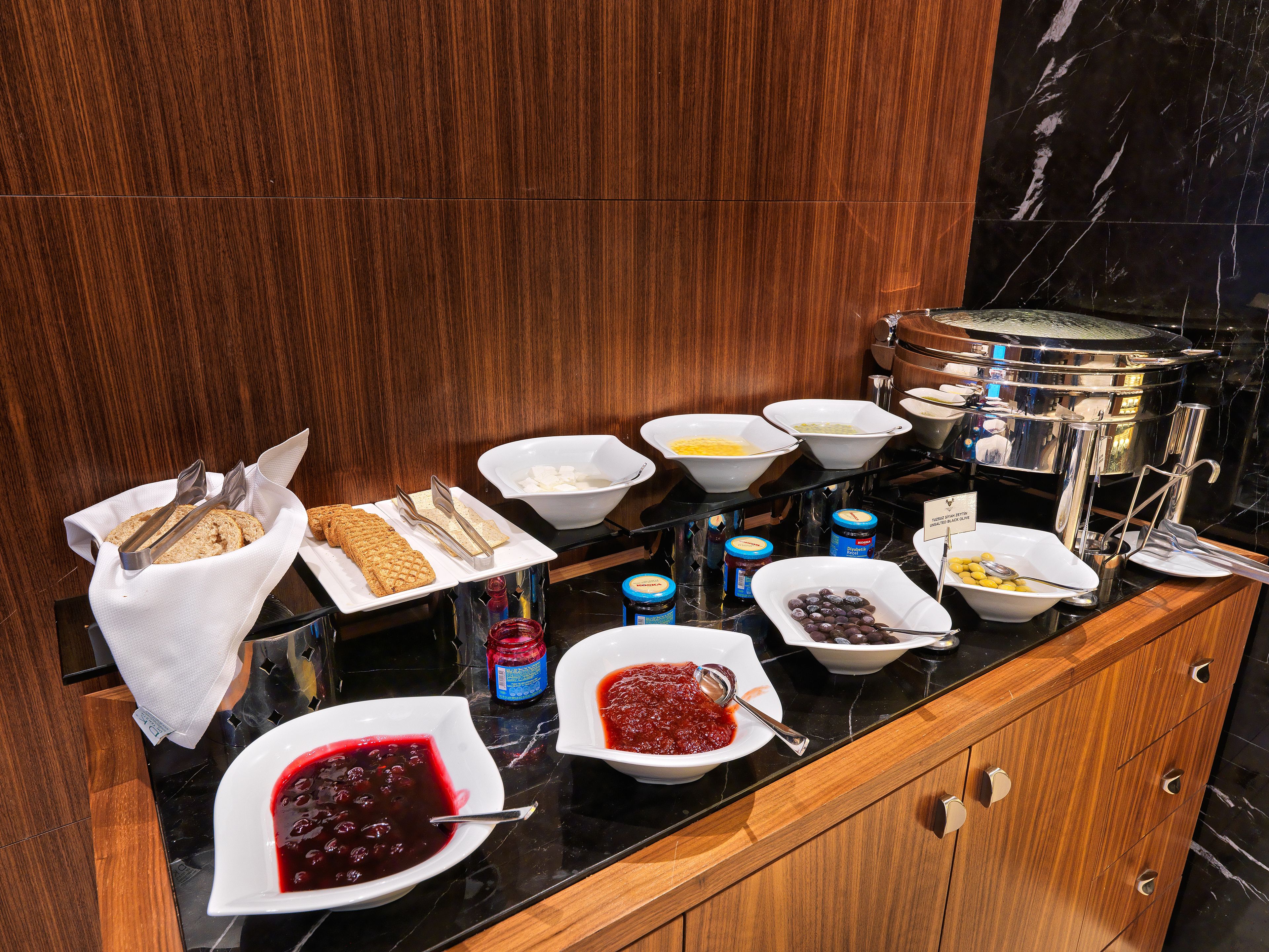 A buffet with various food items and utensils.
