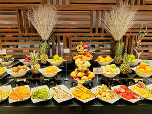 Een buffet met verschillende soorten fruit en groenten, netjes gepresenteerd op een tafel.