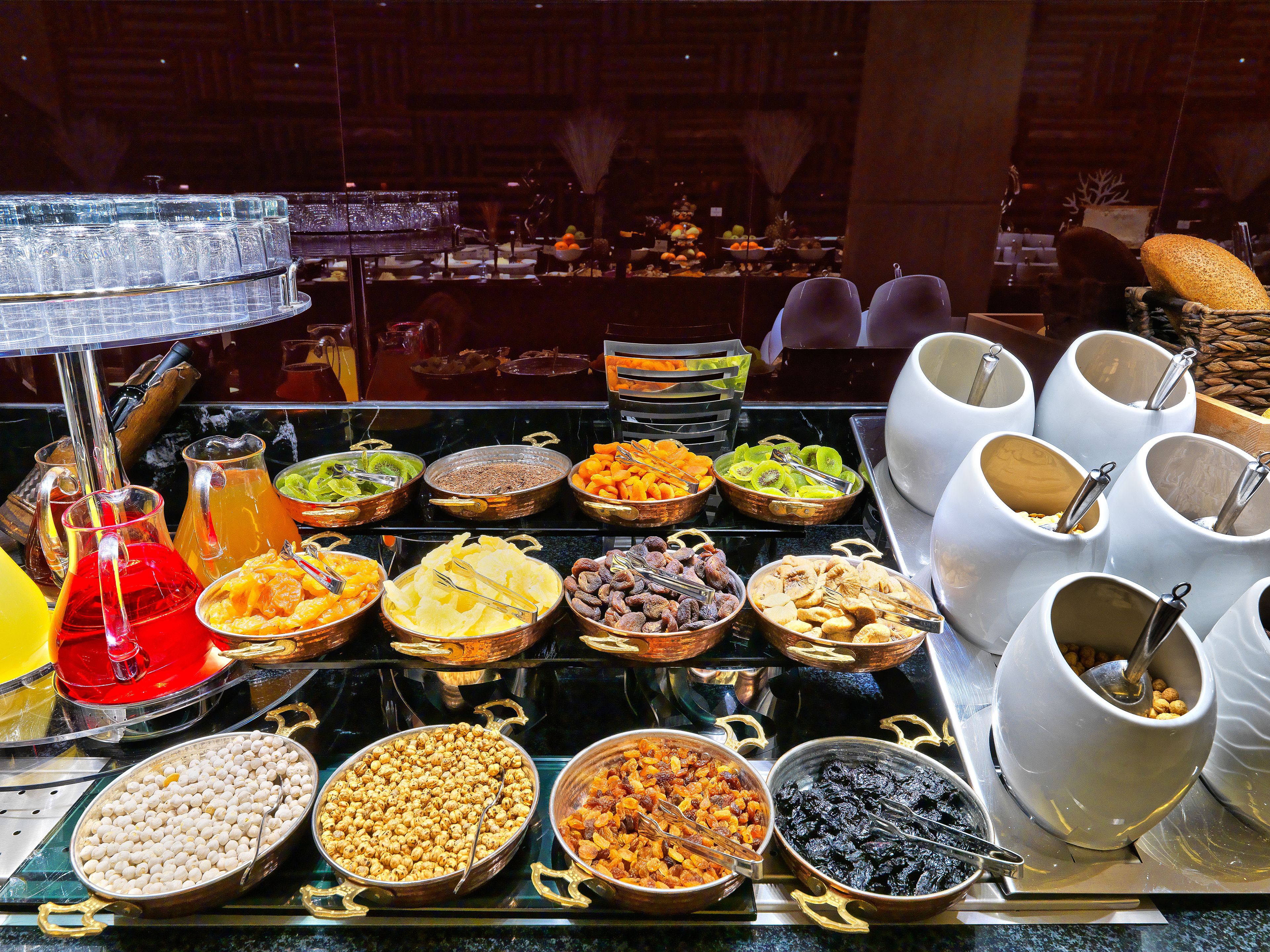 A buffet with various food options including fruits, nuts, and cereals.