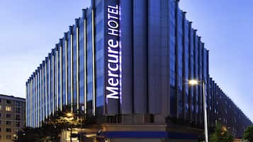 Ein modernes Hotelgebäude mit einer auffälligen vertikalen Beschilderung mit dem Schriftzug "Mercure Hotel".
