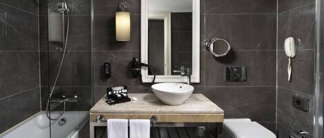 A modern bathroom with a glass-enclosed shower, a white sink, and a toilet.