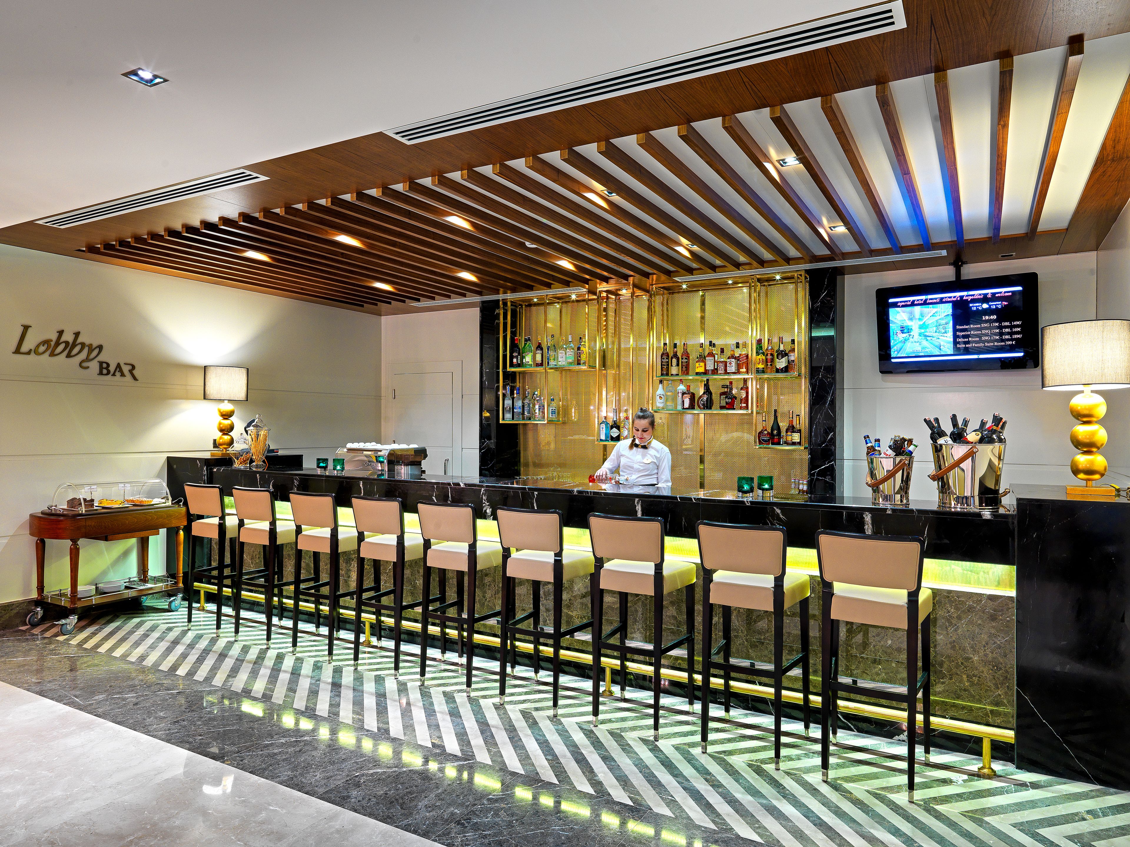A bar area with a bartender, bar counter, and seating.