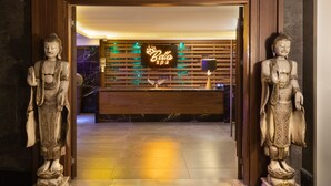 A reception area with two Buddha statues flanking the entrance, a neon 'Bella Spa' sign, and a reception desk with a modern design. - Mercure Istanbul Bomonti (Istanbul)