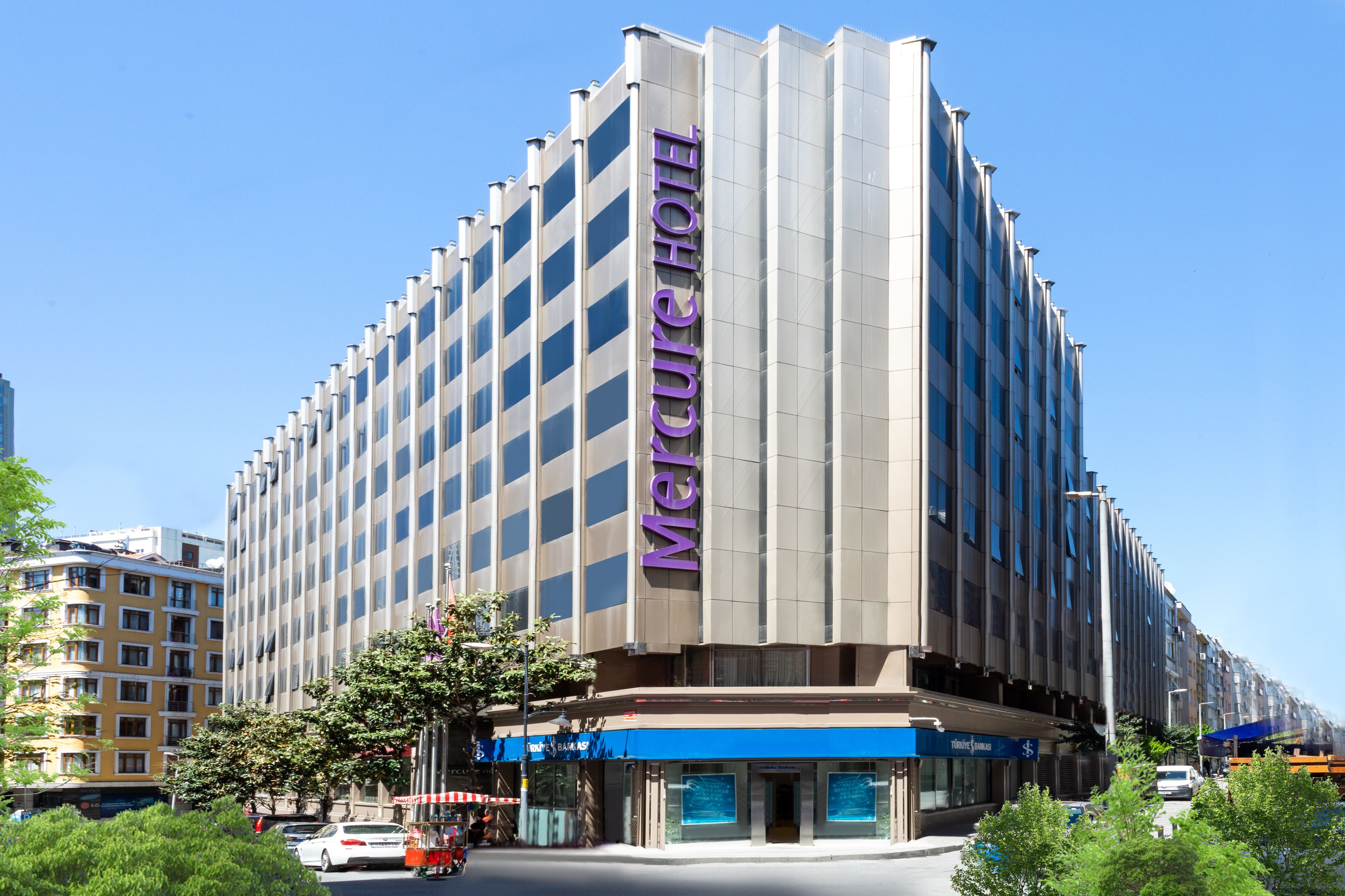 A modern hotel with a prominent vertical sign reading "Mercure Hotel".