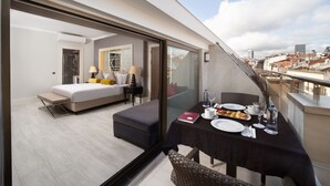 A modern hotel room with a balcony, a dining table set with plates and glasses, and a bed with a nightstand. - Mercure Istanbul Bomonti (Istanbul)