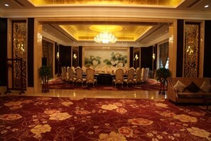 Un comedor formal con una larga mesa, sillas y una lámpara de candelabro.