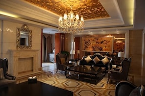 A luxurious living room with a chandelier, a fireplace, a large painting, and a modern sofa set. - Guo Erluosi Hotel (Songyan)