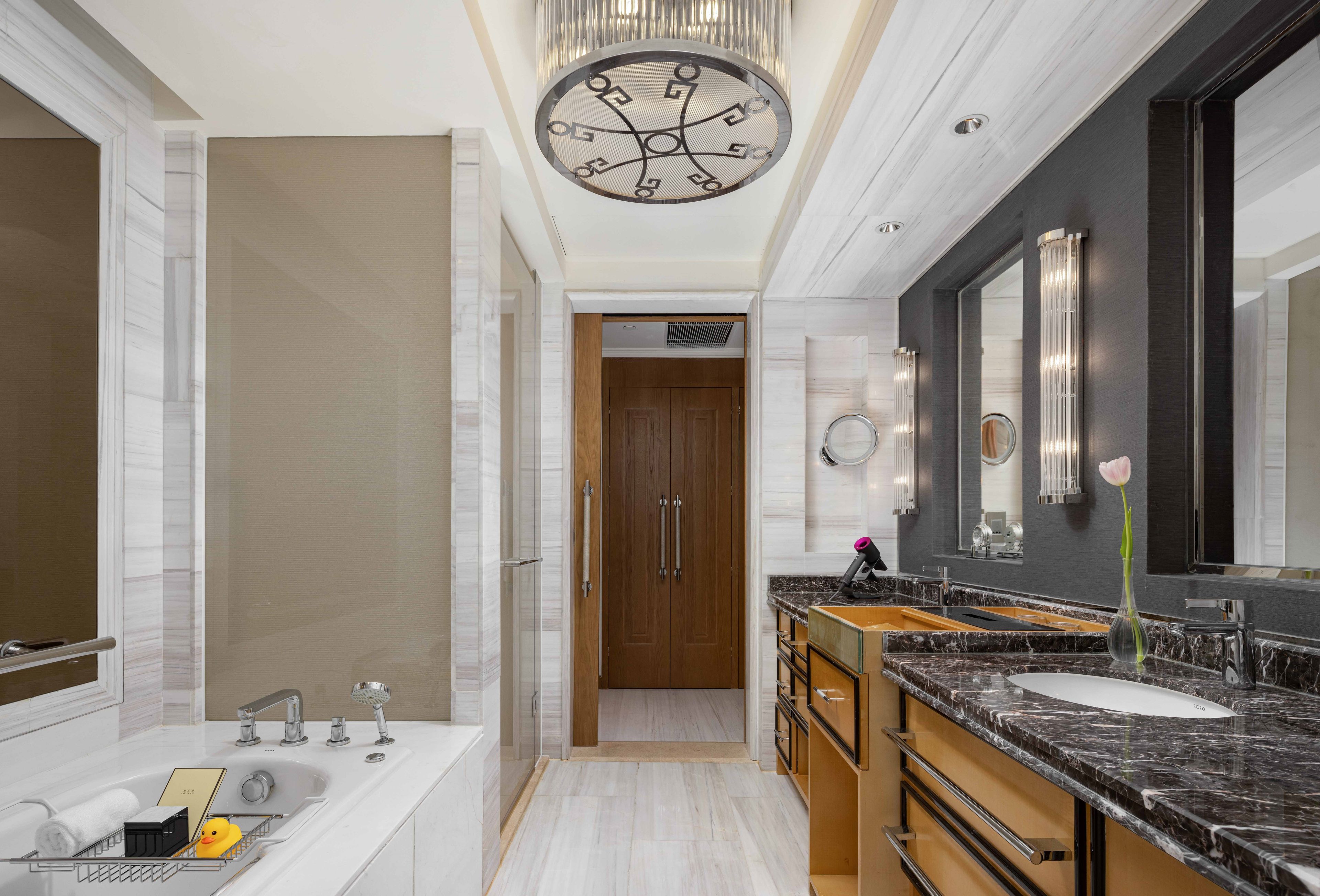 Une salle de bain moderne avec un grand miroir, une baignoire et un meuble-lavabo.
