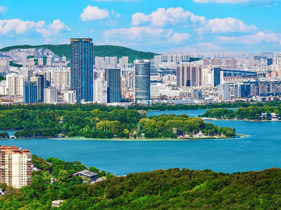 Un horizonte urbano con rascacielos, un río y una pequeña isla con vegetación.