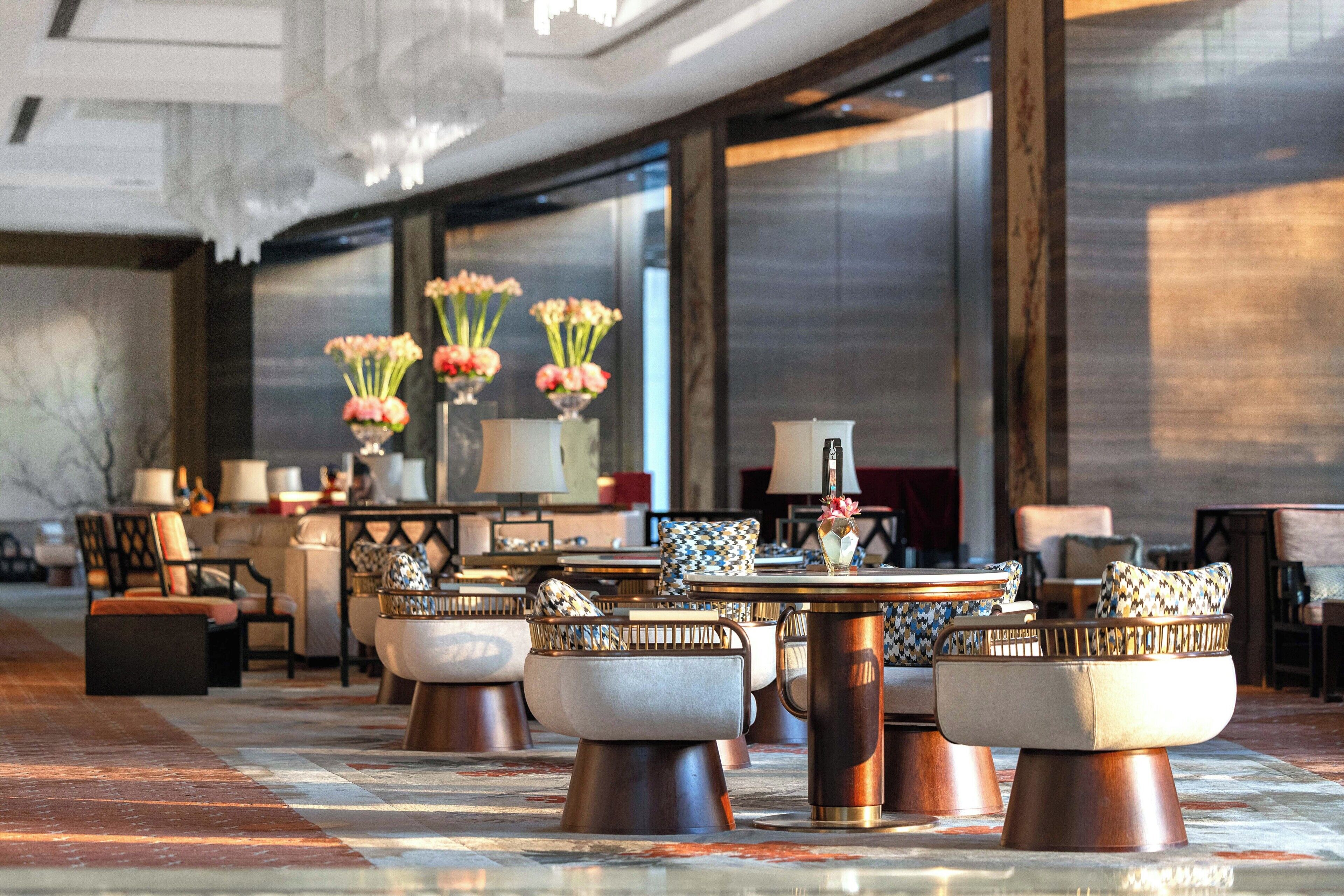 A modern lobby with seating arrangements, a coffee table, and decorative vases.