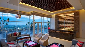 A modern living room with a large window, a wine rack, and a reception desk. - Cinnamon Red Colombo (Colombo)
