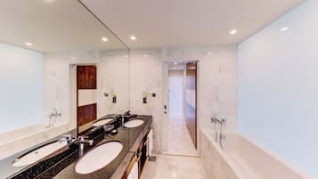 A modern bathroom with two sinks, a bathtub, and a mirror.