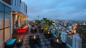 A rooftop bar with checkered flooring, seating, and a city view. - Cinnamon Red Colombo (Colombo)