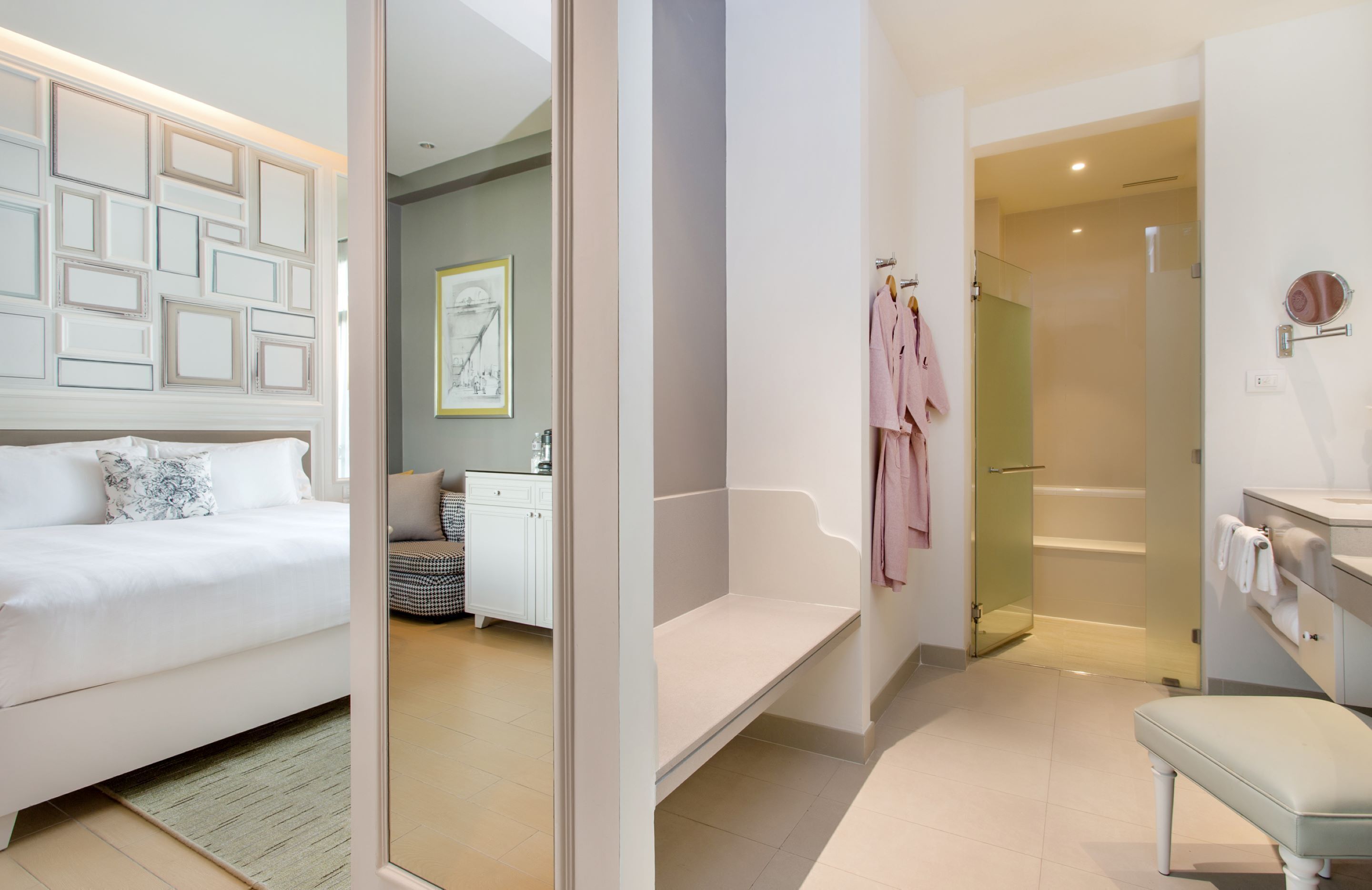 A modern bedroom with a bed, bedside table, and a view into the bathroom.