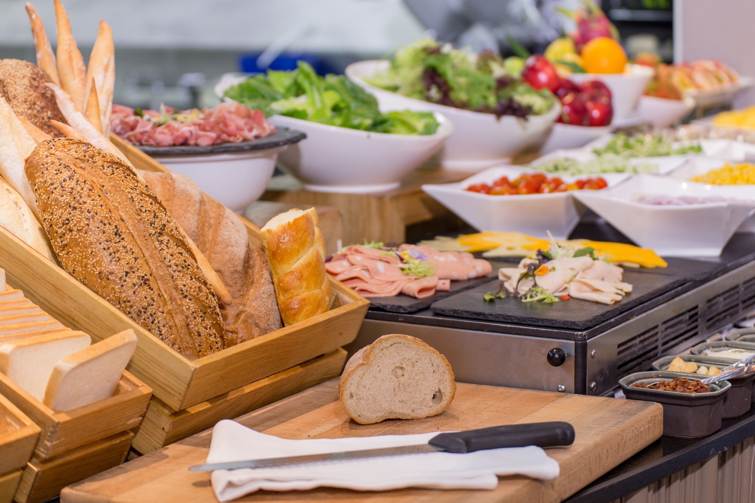 A buffet with various food items including bread, salads, and meats.