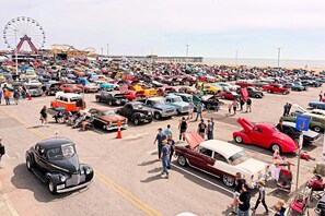 A crowded parking lot with various vintage cars and a Ferris wheel in the background. - Holiday Inn Express & Suites West Ocean City by IHG (Ocean City)