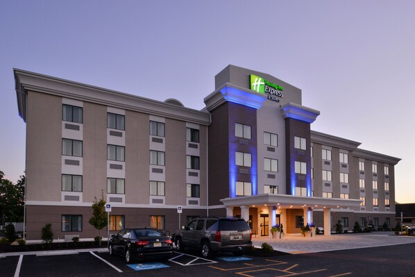 Een Holiday Inn Express hotel met een moderne gevel, diverse parkeerplaatsen en een uitnodigende entree.