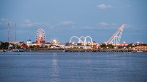 A waterfront view with a Ferris wheel, roller coaster, and a large white structure. - Holiday Inn Express & Suites West Ocean City by IHG (Ocean City)