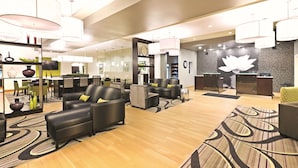 A spacious lobby with leather sofas, a reception desk, and modern lighting fixtures.