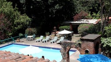 Alberca al aire libre y camastros