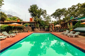 Alberca al aire libre y camastros 