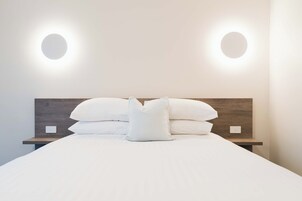 Escritorio, tabla de planchar con plancha y ropa de cama 