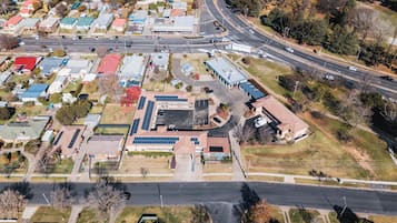 An aerial view of a commercial area with multiple buildings, roads, and a highway.