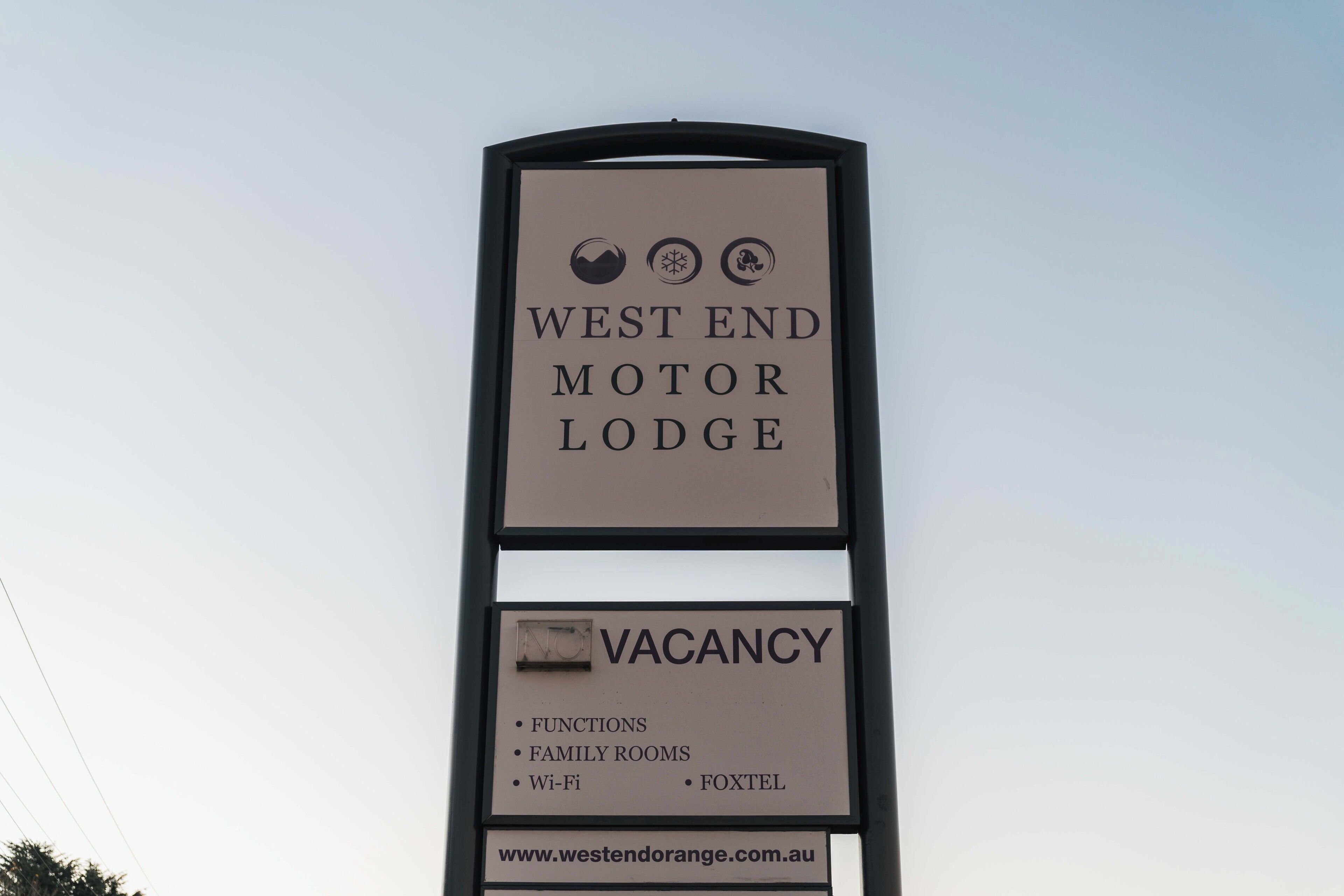 A sign for West End Motor Lodge advertising a vacancy, listing amenities like functions, family rooms, Wi-Fi, and FoxTel.