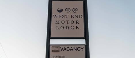 Bord voor West End Motor Lodge met een melding van een beschikbaarheid, met faciliteiten zoals vergaderzalen, familiekamers, Wi-Fi en FoxTel.