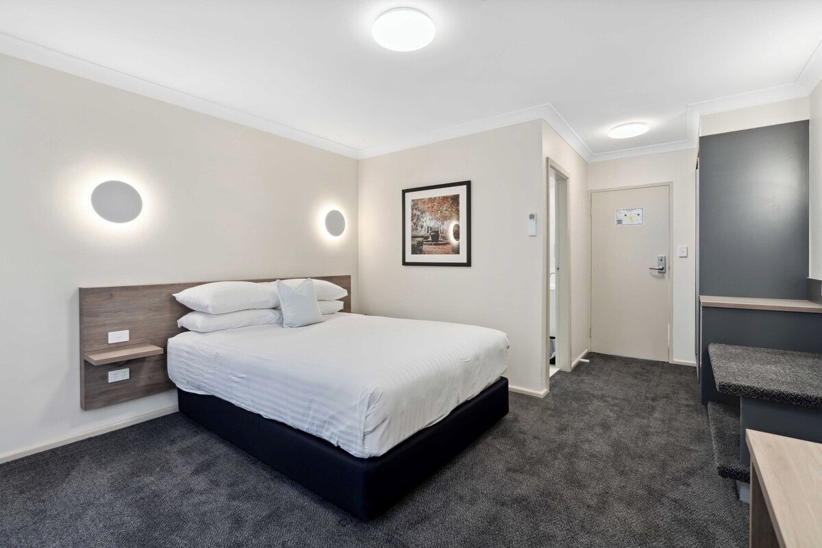 Desk, iron/ironing board, bed sheets