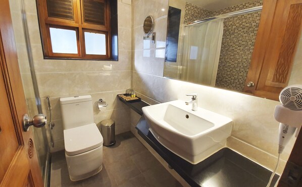 Un bany modern amb vàter, rentamig i plat de dutxa.