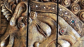 A detailed carved wooden panel with intricate designs, including floral patterns and a central figure.