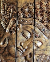 A detailed carved wooden panel with intricate designs, including floral patterns and a central figure.