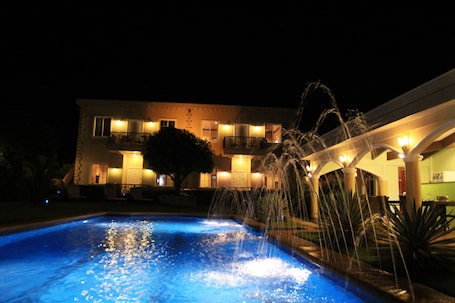 Una piscina al aire libre, sillones reclinables de piscina