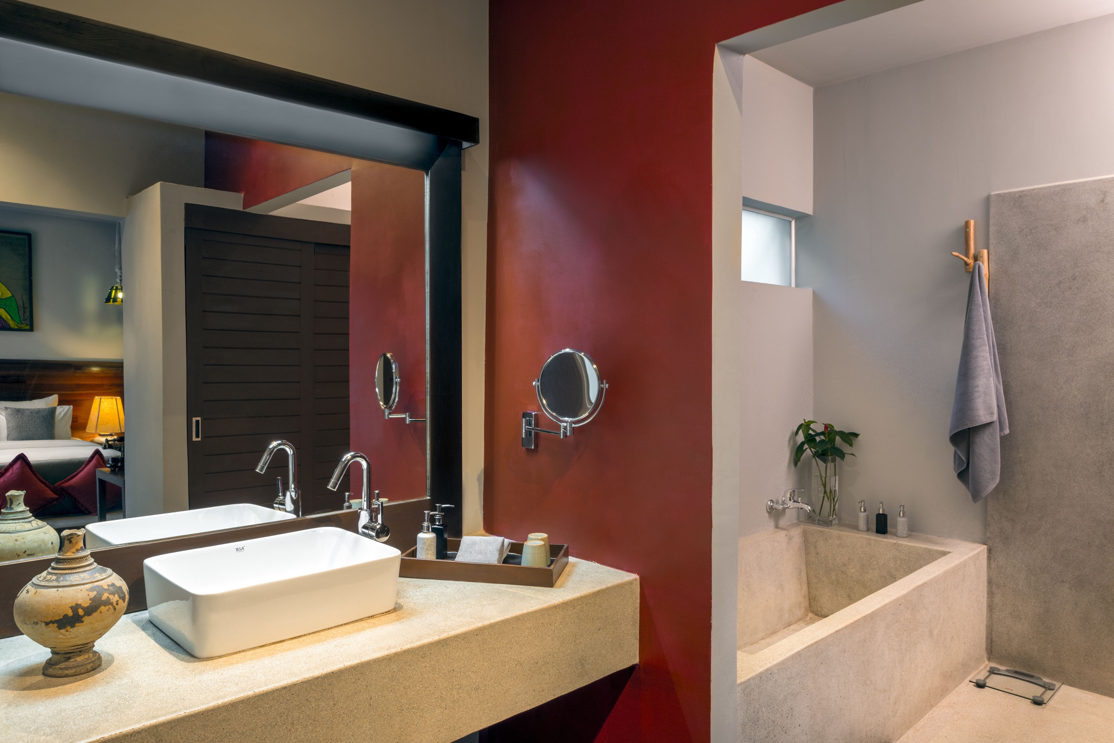 Un bagno moderno con uno specchio grande, due lavandini, una vasca da bagno e un porta asciugamani.