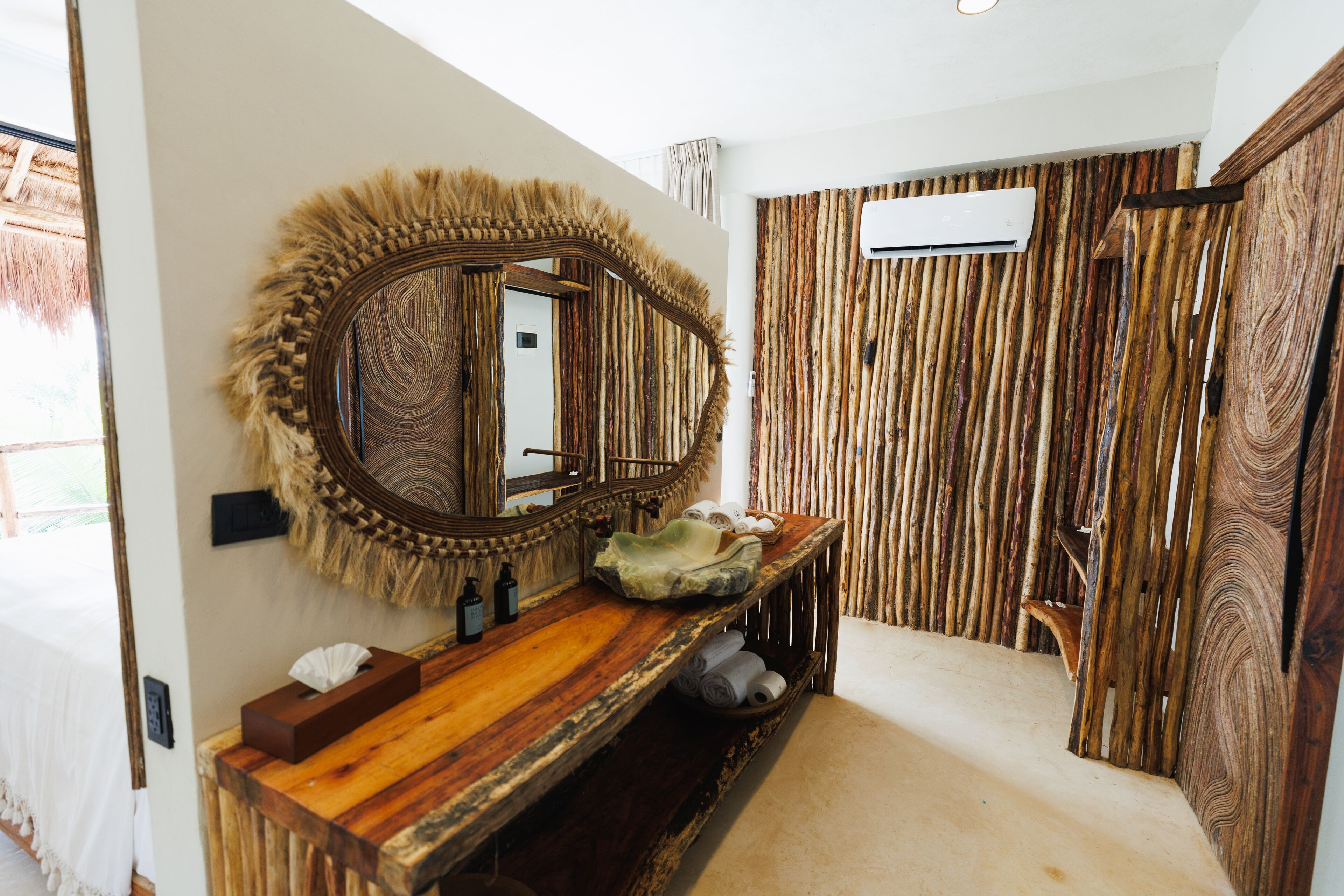 Une salle de bain avec un meuble-lavabo en bois, un grand miroir et un mur recouvert de panneaux de bois verticaux.