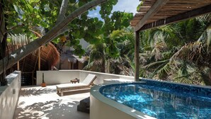 A pool area with lounge chairs and a thatched-roof structure. - Solaya Boutique Hotel (Tulum)