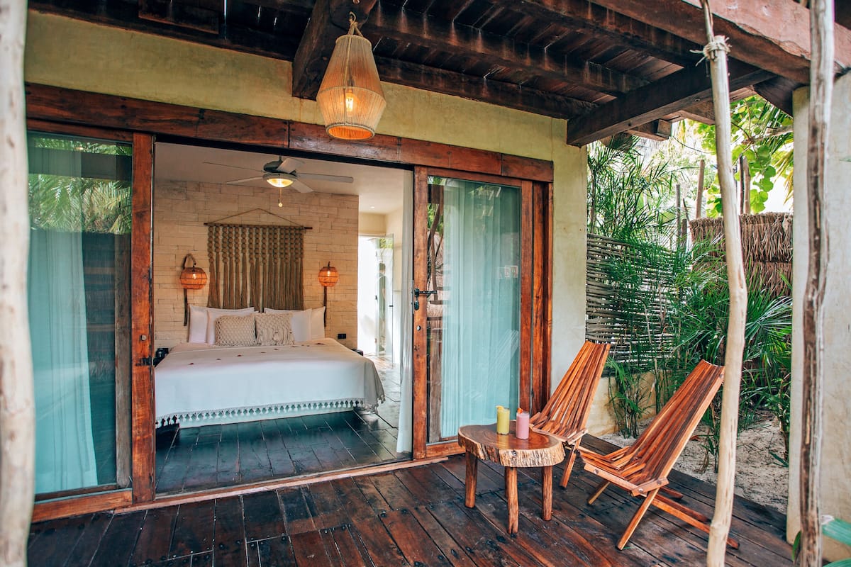 Ein Schlafzimmer mit einem Bett, einem Deckenventilator und einem Holztisch mit Stühlen.