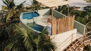 A pool area with two hot tubs, surrounded by palm trees and overlooking a beach. - Solaya Boutique Hotel (Tulum)