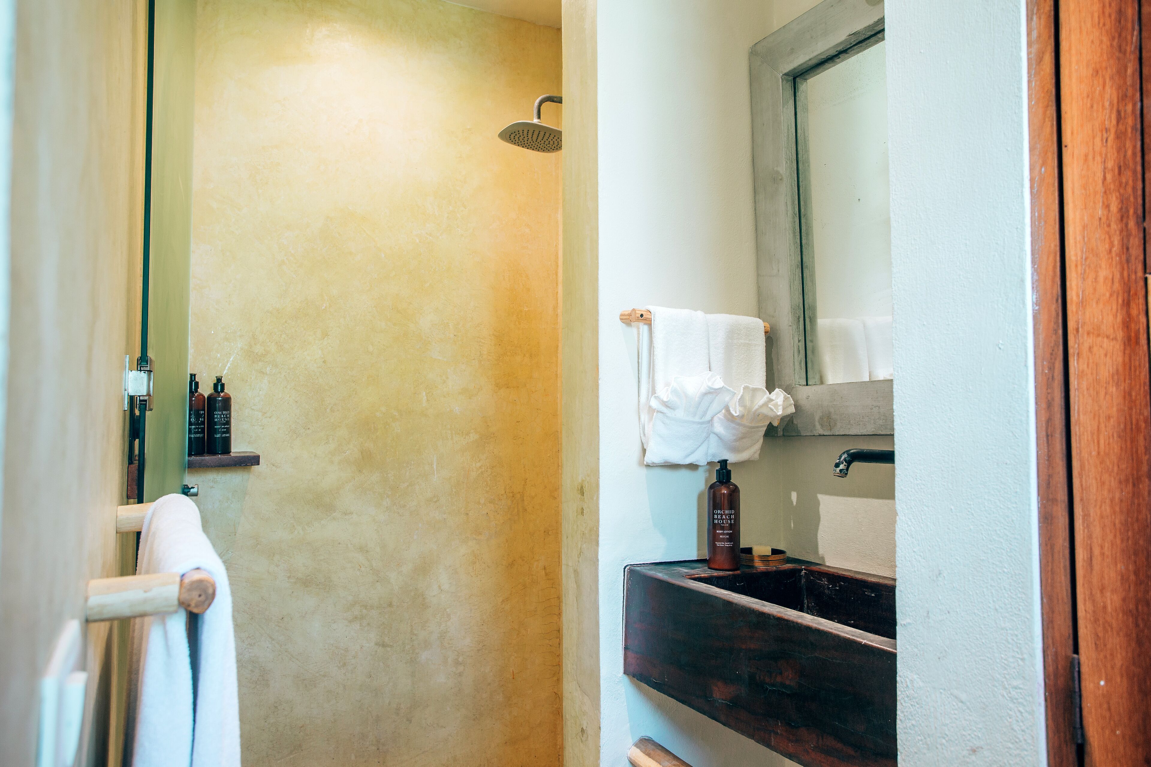 A bathroom with a shower, a sink, and a mirror.