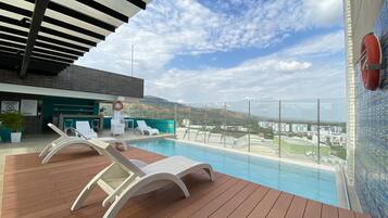 Relax by the pool surrounded by a scenic view of the surrounding landscape.