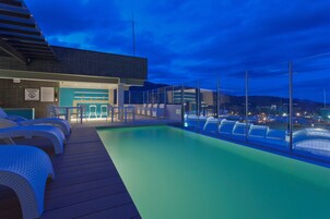 Una piscina al aire libre, sillones reclinables de piscina
