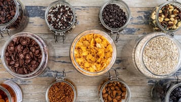 A variety of food items in glass jars on a wooden surface.