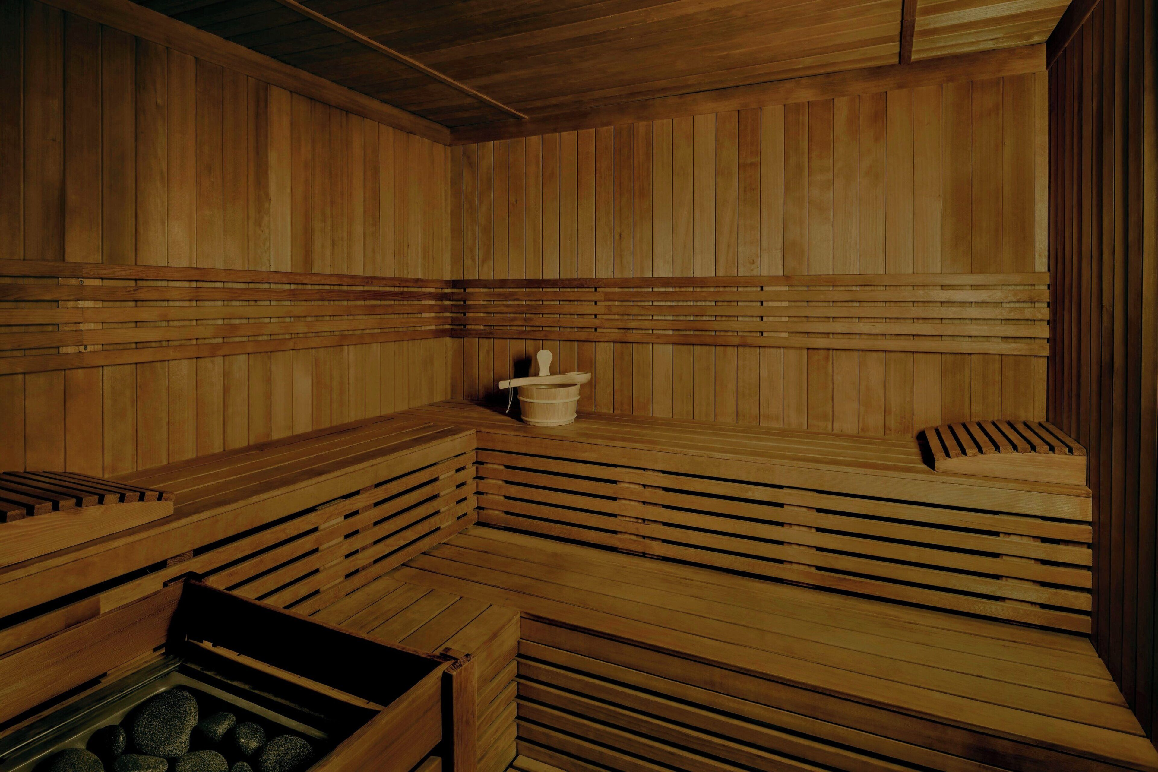 A wooden sauna with benches and a stone basin.