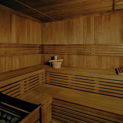 A wooden sauna with benches and a stone basin.